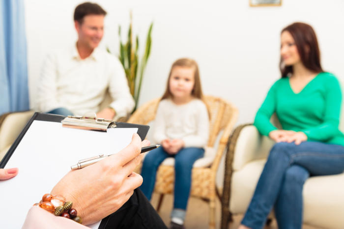 Parenting coordinator talking to a couple and their child